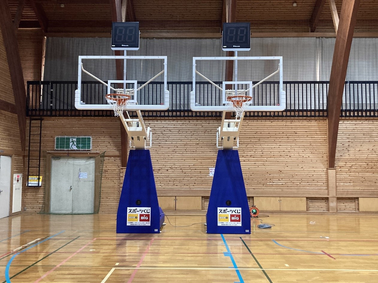 バスケットボールのゴールが2つ設置された体育館の内部の写真。