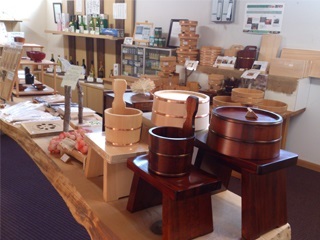 木製の曲げわっぱや桶や器が木製の台に並び店のディスプレイとして展示されている光景