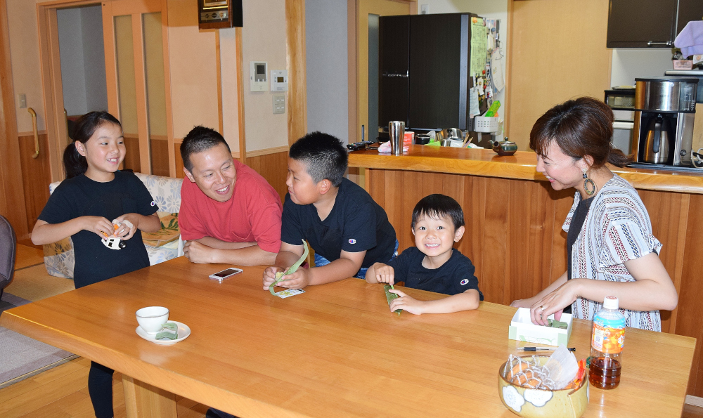 ダイニングテーブルを囲んで会話をしている家庭の室内風景