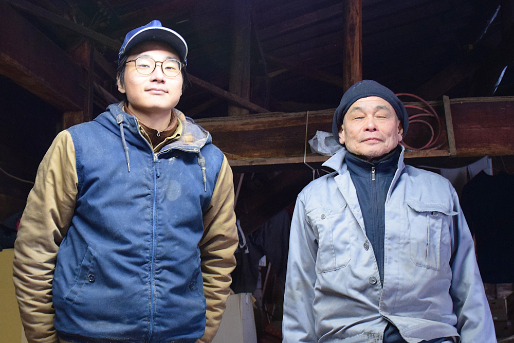 屋内で二人の人物が並んで立っている