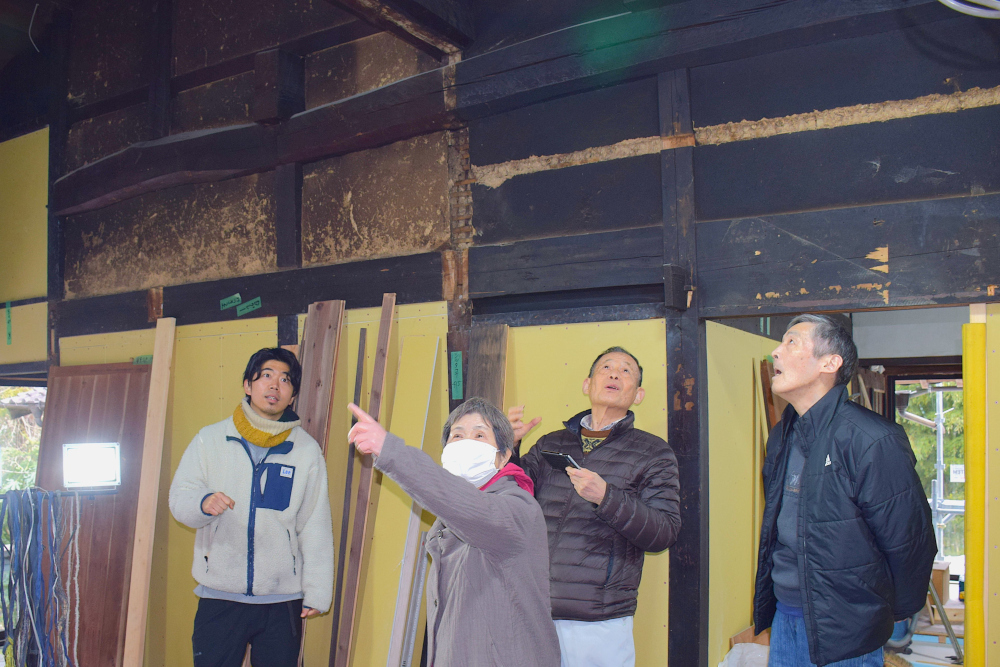 室内の古い建物で複数の人が立って話している様子