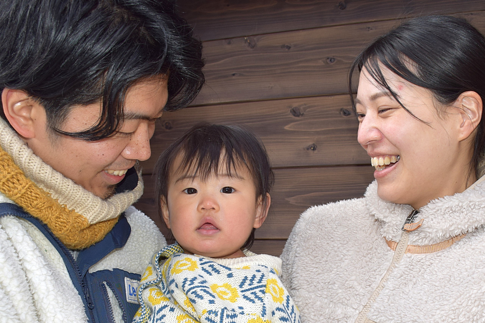 二人の大人と中央に子どもが並んでいる