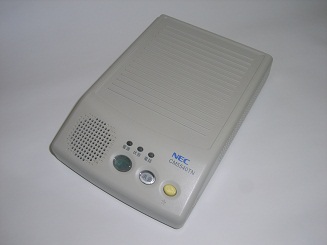 薄い灰色のデバイスの上面が写っており、スピーカーやボタンが見える。